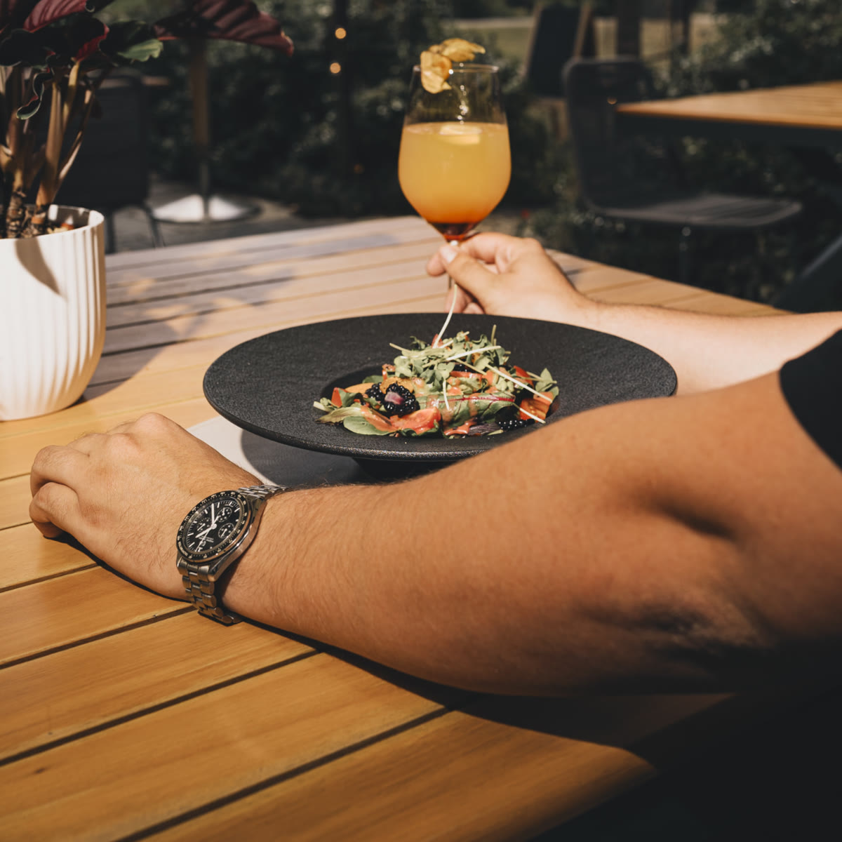 Gast mit Spritz am Terrassentisch