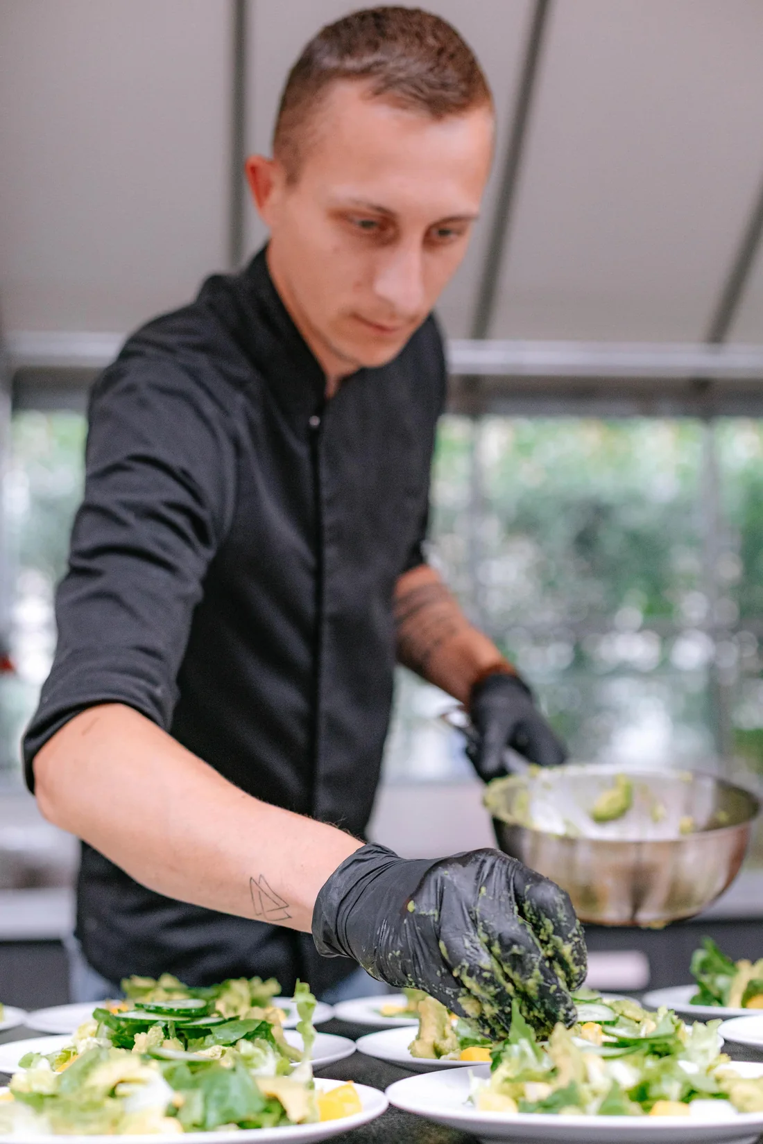 Roland richtet frische Salate für die Gäste an