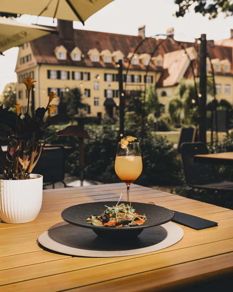 Gedeckter Terrassentisch mit Blick auf das Gutshaus Piusheim